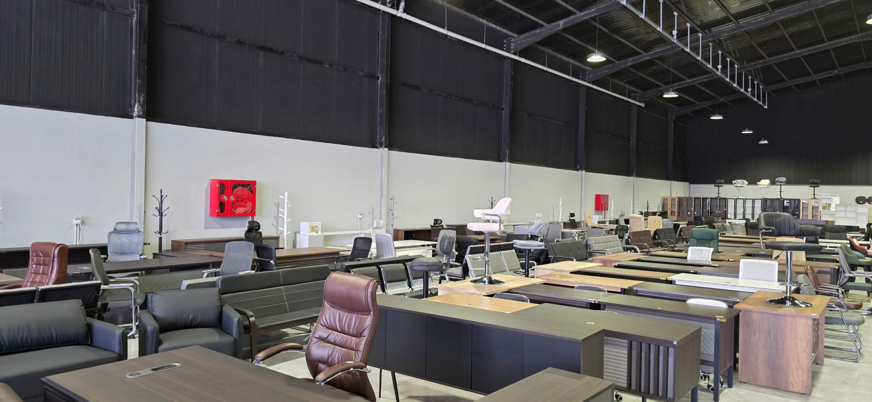 Wide customer showroom proof with desks, storage and meeting-area furniture mix